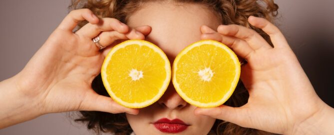 woman holding sliced orange fruit